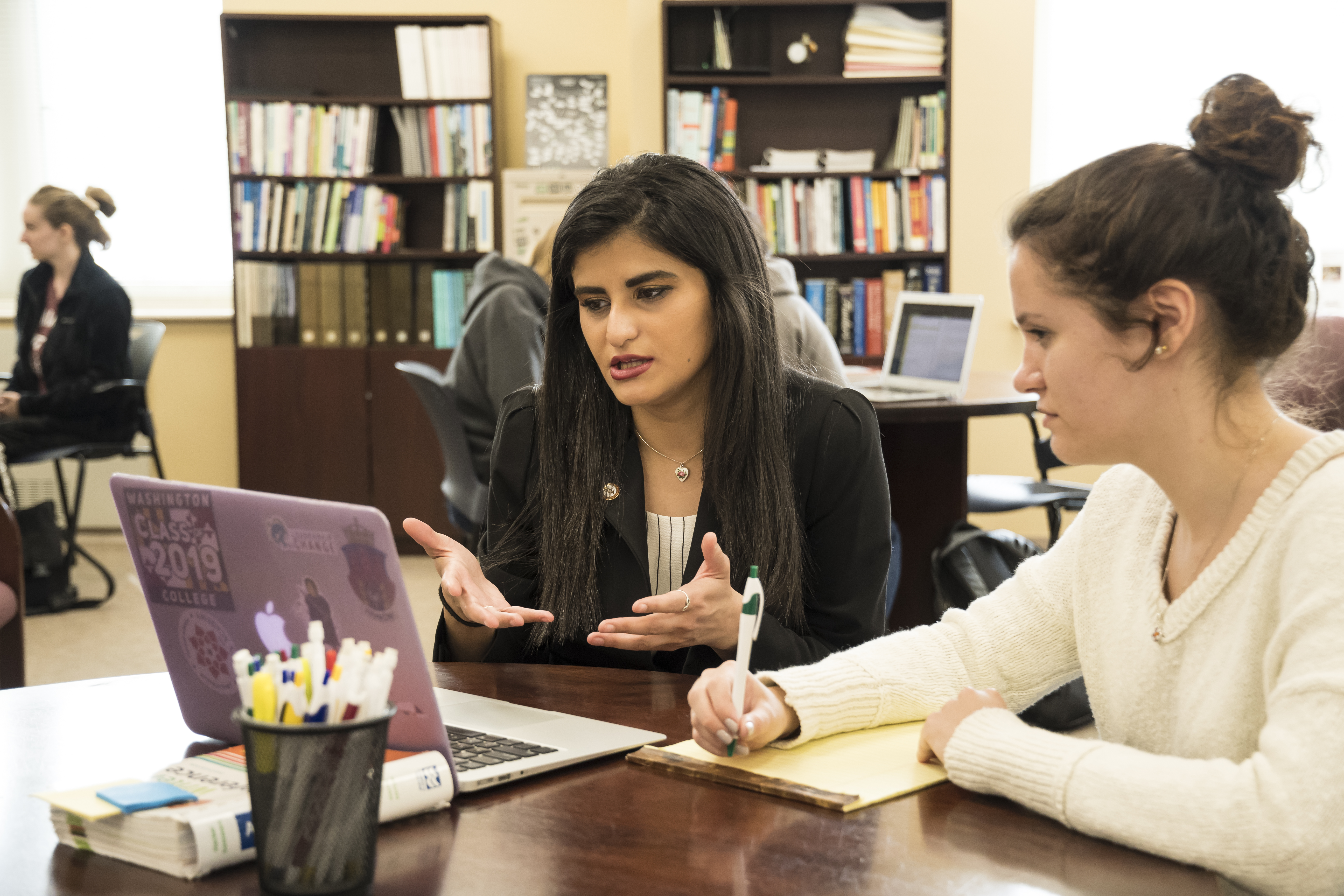 Two Washington College students look at a laptop