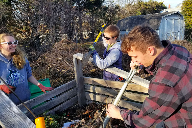 Students create a new 18-day compost pile at the campus garden.