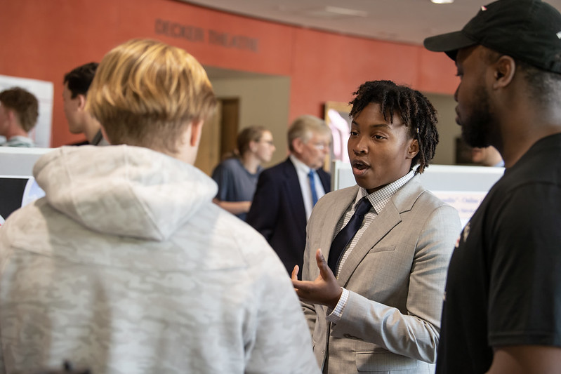 Joy Sanders discusses her research during the business capstone poster session