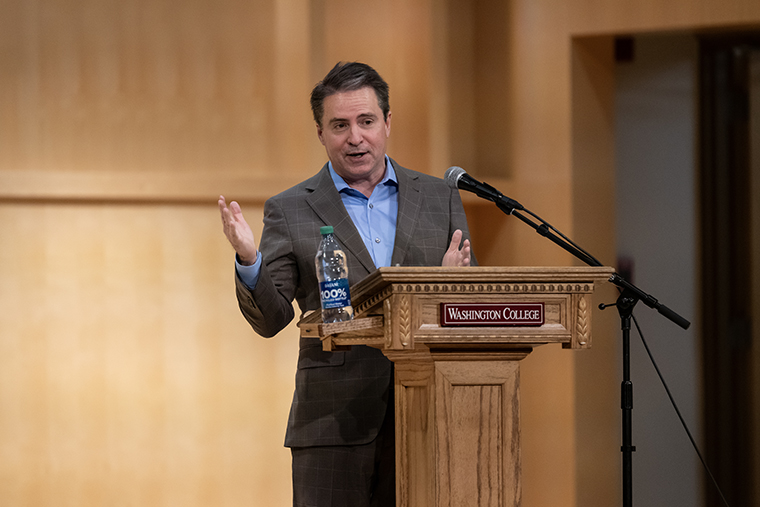 Robert P. Jones speaks behind a lectern that has a "Washington College" placard on it